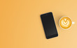 Modern workspace with coffee cup and smartphone copy space on orange color background. Top view. Flat lay style.