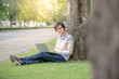 © zephyr_p - Young Asian happy man using laptop computer in the garden, male university student relaxing outdoor, education and technology concepts