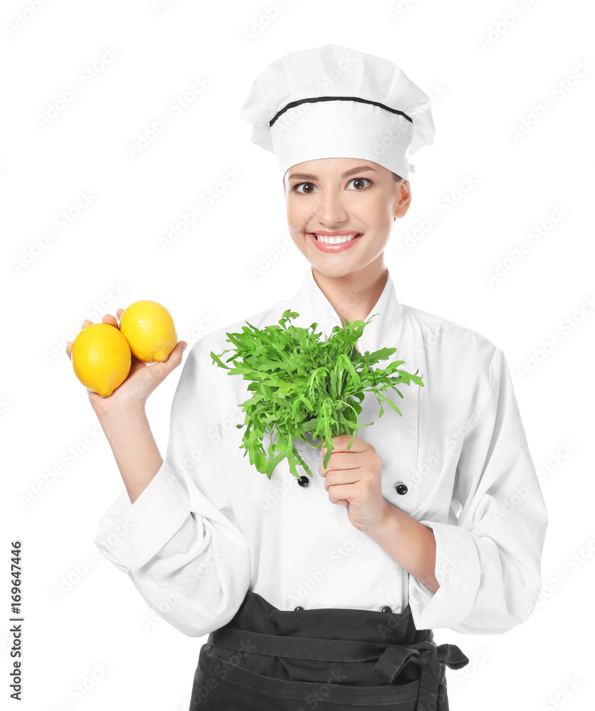 Young female chef with ruccola and lemons on white background