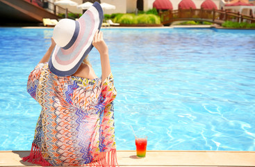 Wall Mural - Beautiful young woman near swimming pool