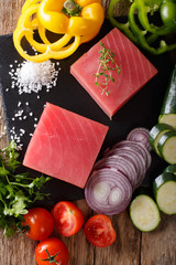 Wall Mural - Raw steaks from tuna and fresh vegetables, spices macro. Vertical top view