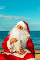 Santa Claus is resting on the beach.