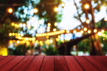 empty wooden desk, terrace or floor copy space for display of product or object presentation with blurred image of abstract night light bokeh of night festival in garden background, vintage tone