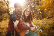 © BalanceFormCreative - Young couple sitting on bicycle at the park on autumn day.Love and making fun.