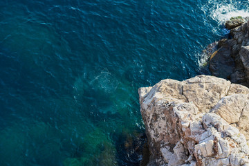 Adriatic sea waves background with top view of tiny rocky isle