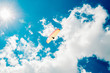 © bnenin - Parachuter descending with a yellow parachute against blue sky