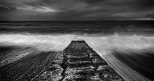 Breakwater Construction On Welsh Shore, Dynamic Black And White Seascape