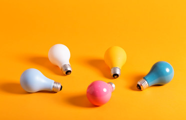 Colored light bulbs in arranged on a yellow background