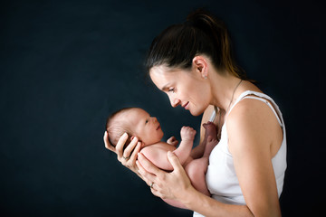 Sticker - Young mother, kissing and hugging her newborn baby boy