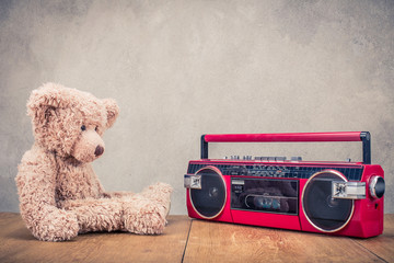 Wall Mural - retro teddy bear toy and red old outdated cassette radio recorder from 80s front concrete wall backg