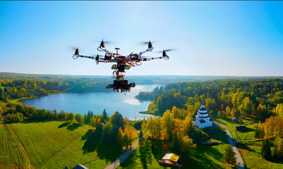 drone with professional cinema camera flying over a autumn park in fall colors under morning light with deep long shadows