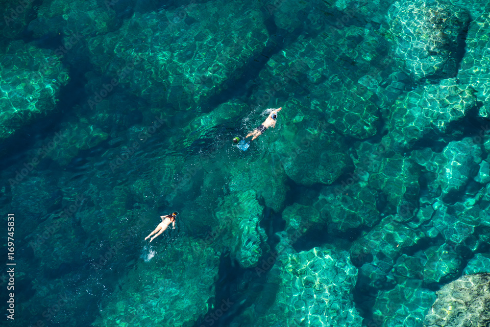 Above view of a couple snorkeling in the sea - obrazy, fototapety, plakaty 