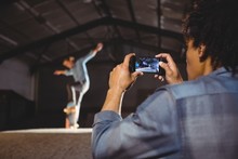 Man Taking A Video Of Skateboarding Tricks