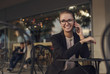 © xo4uphoto - Business woman sitting in cafe and talking on the phone and smiling
