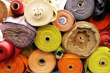 Fabric rolls with many different colors in shelf for fashion industry.