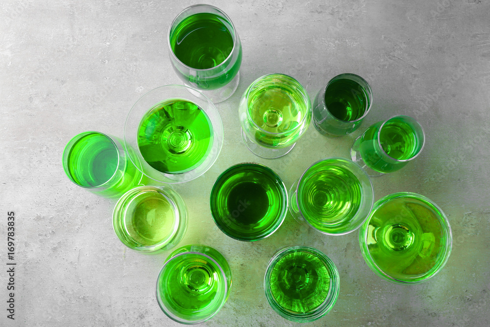 Composition with many glasses of green cocktail on table