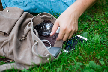 mans hand take power bank from backpack