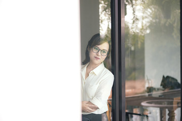 Wall Mural - View of Through a glass window, Asian girl business thinking ide