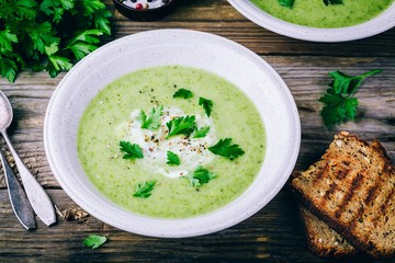 Wall Mural - bowl of green zucchini cream soup with fresh parsley