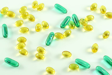 Fish oil capsule, yellow soft gels capsules, Yellow oil pills and blue pill, capsule isolated on white background