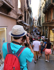 young photographer takes a picture to people walking