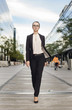 © xo4uphoto - Serious business woman walking at the street