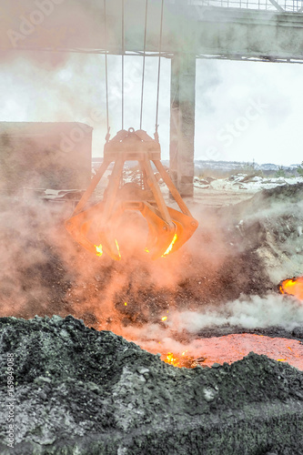 Fotografia, Obraz Mechanical multivalve clamshell grapple for transportation of red-hot pieces of iron from the melt