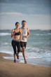 © jackfrog - A couple wearing sportswear is running on the beach