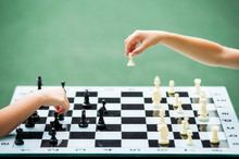 A Boy And A Girl Are Playing At A Chess Table