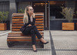© xo4uphoto - Business woman sitting at the bench looking at camera