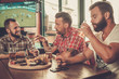 © Nejron Photo - Friends drinking beer and watching soccer in a pub