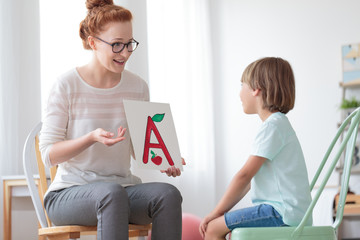 Wall Mural - Friendly speech therapist and boy