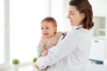 Canvas Print - doctor or pediatrician holding baby at clinic