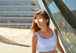 © franciscopgr - Chica joven con gafas de sol junto a un edificio moderno y futurista de cristal