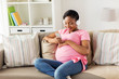 © Syda Productions - pregnant woman in headphones with smartphone