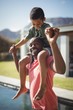 © WavebreakMediaMicro - Father carrying son on shoulders near poolside