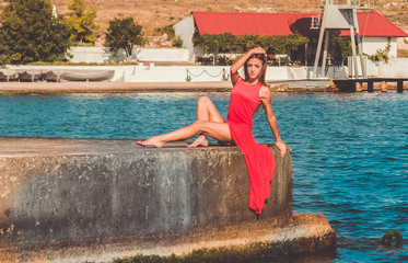 Pretty fit girl in a peach dress on a seashore