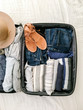 © Daniel Kim Photography/Stocksy - Suitcase with packed clothes and accessories