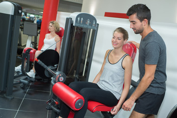 Wall Mural - personal trainer helping women working out in gym