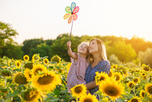 Mom And Daughter In The Field Of Sunflowers
