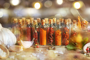 Wall Mural - Assorted dry spices in glass bottles on dark background