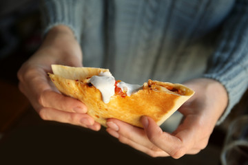 Wall Mural - Woman eating delicious quesadilla with sauce in restaurant