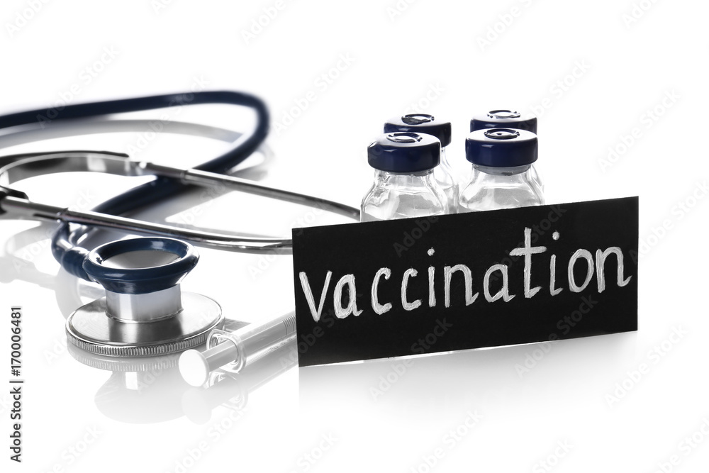 Card with word VACCINATION, ampules, stethoscope and syringe on white background