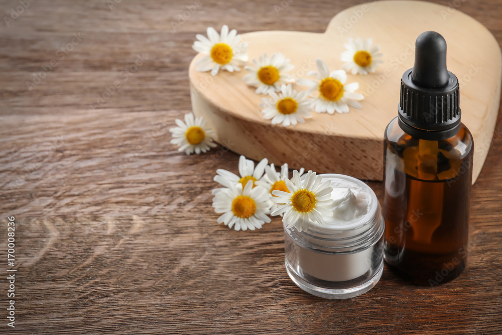 Composition with chamomile essential oil and cream on table