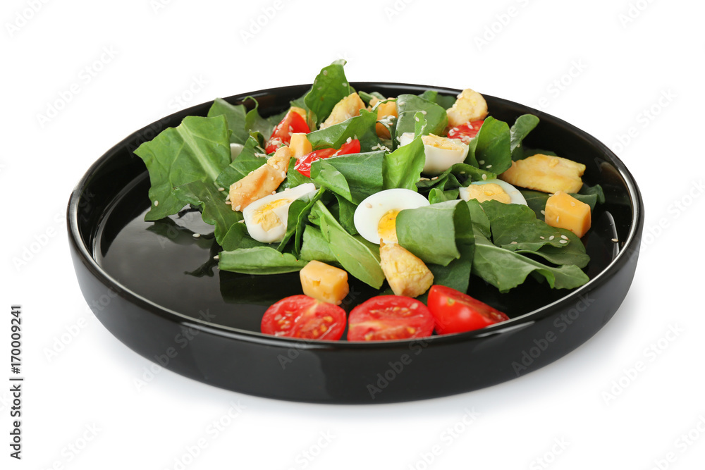 Plate of salad with quail eggs and spinach isolated on white