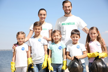 Sticker - Young volunteers and children with garbage bags on beach