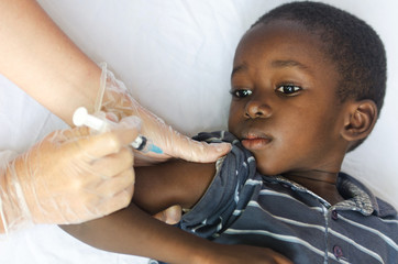 Wall Mural - Vaccination for African children: little black boy getting an injection from a nurse