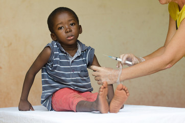 Wall Mural - Sad African boy ready to get an injection from a volunteer nurse in Bamako, Mali