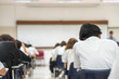 Education blur background back view university students writing answer doing exam in school classroom