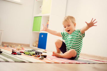 Wall Mural - Little child playing with toy cars